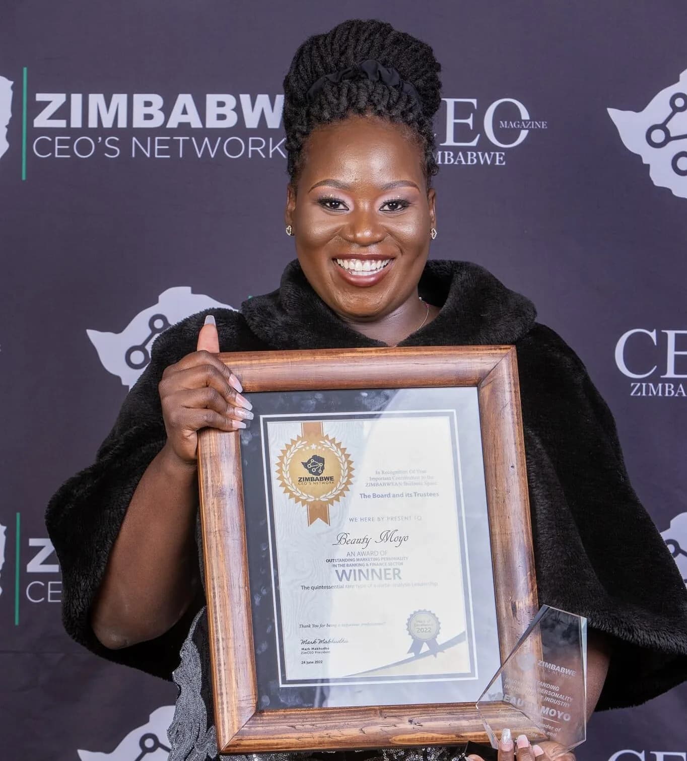 Beauty Moyo holding her Zimbabwe CEO Network award certificate