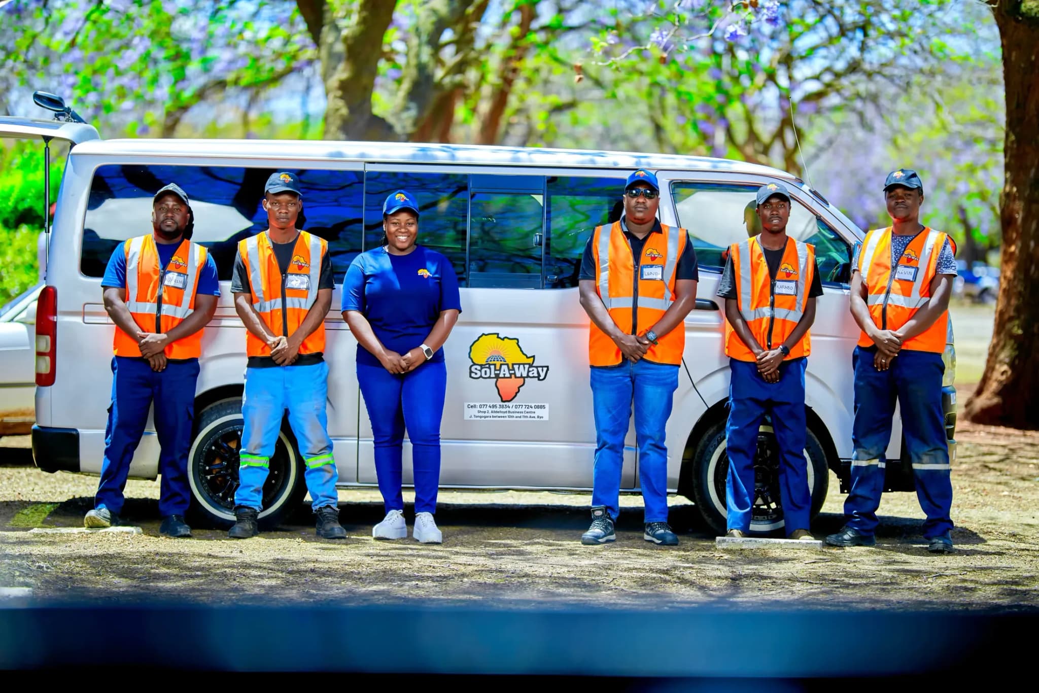 Six Sol-A-Way team members in hi-vis vests and uniform lined up in front of a branded van