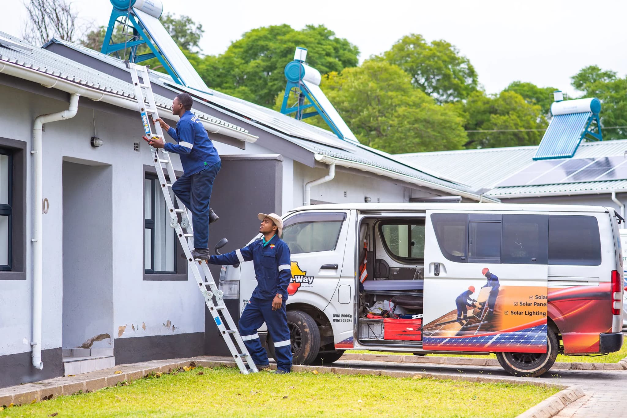 Technician climbing a ladder to the roof beside the Sol-A-Way van