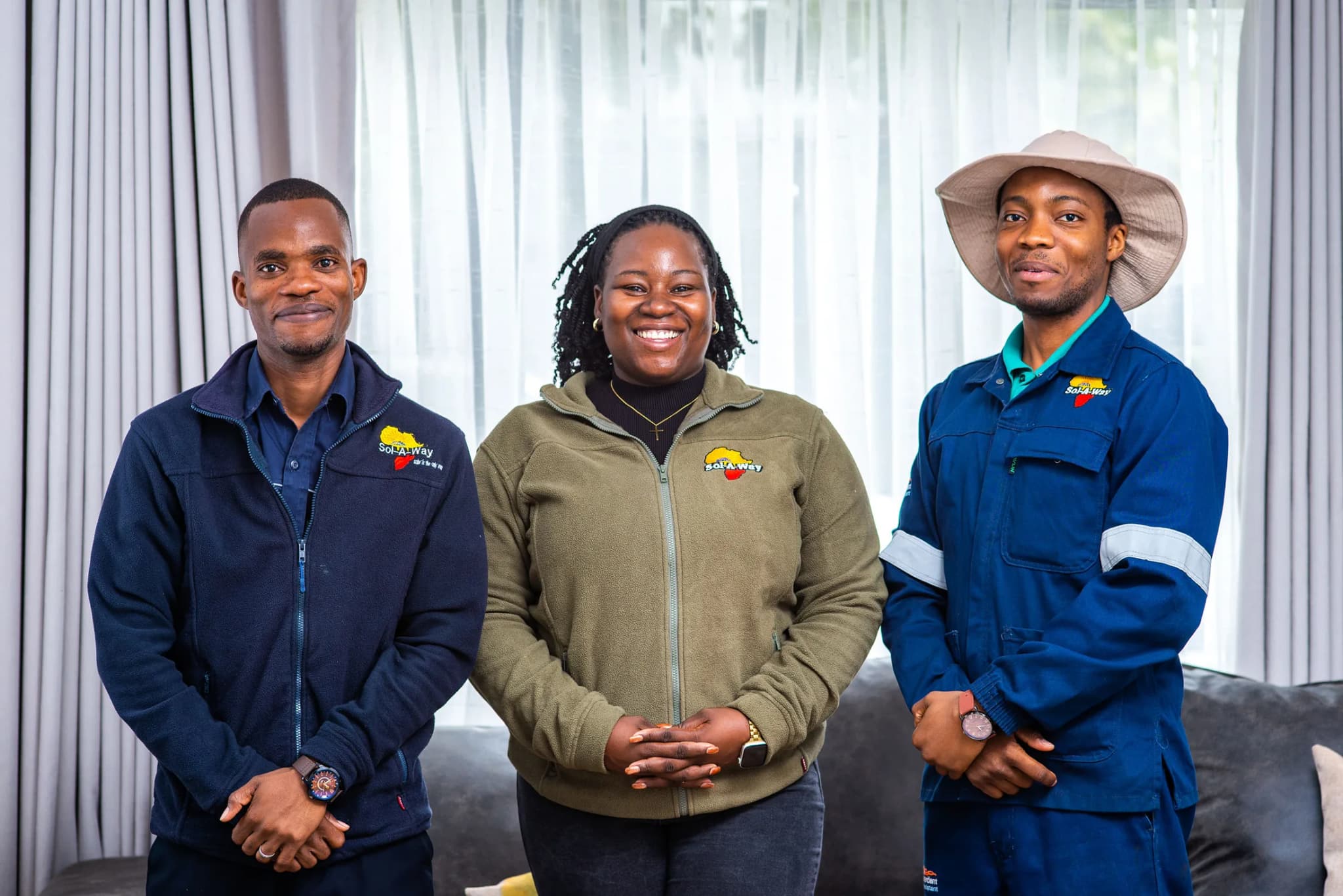 Three Sol-A-Way team members standing together indoors