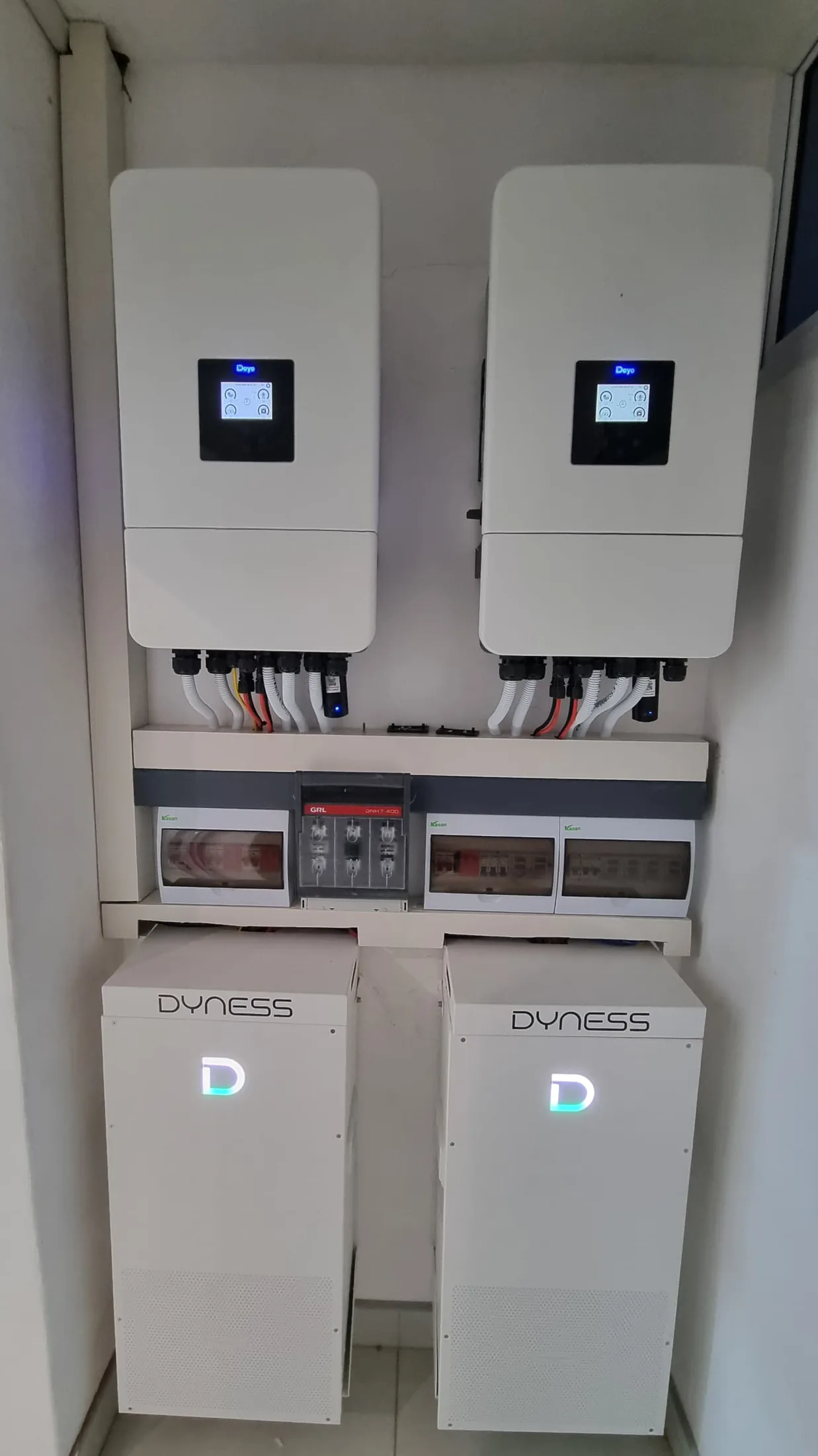 Two inverters above two Dyness lithium battery modules in a cabinet install