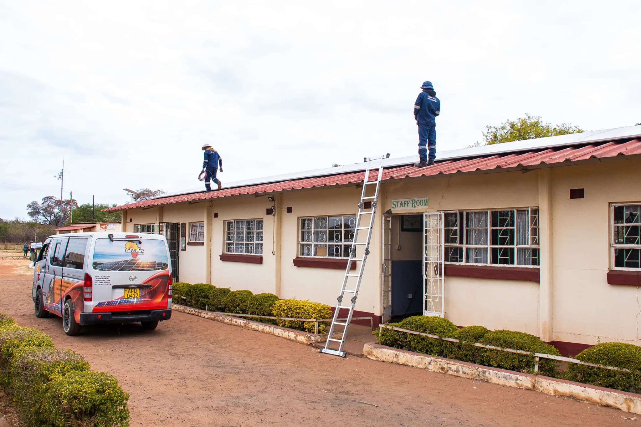 School block with technicians on the roof and the Sol-A-Way van outside